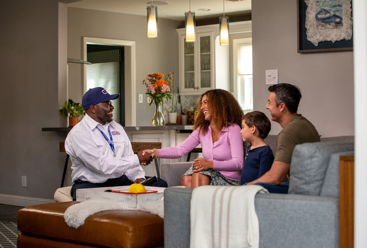 Clark Pest Control technician shaking hands with a family in their California home